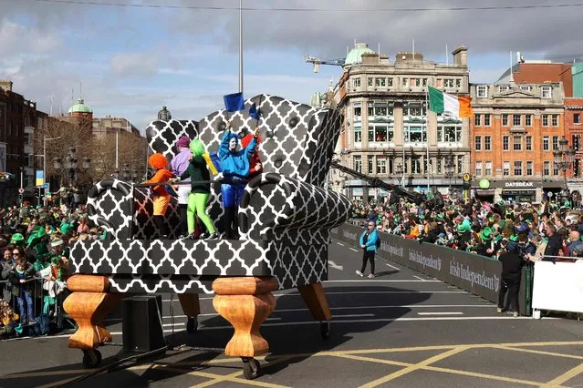 Performers on a giant chair cross O'Connell bridge during the annual St Patrick's Day parade in Dublin, Ireland on March 17, 2022. (Photo by Damien Eagers/AFP Photo)