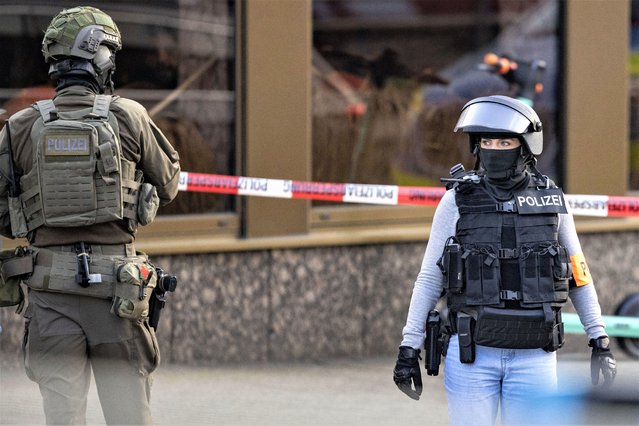 Armed police officers stay in front of a health club in Duisburg, Germany, Tuesday, April 18, 2023. German police say several people have been injured in an attack at a gym in the western city of Duisburg. Tuesday evening’s attack occurred in the old city of Duisburg and police asked residents to avoid the area. (Photo by Christoph Reichwein/dpa via AP Photo)