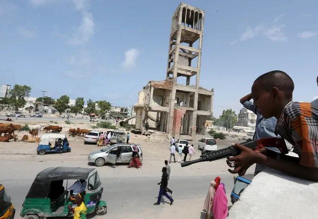 A boy holds his toy gun near former Somali parliament during the celebration after attending Eid al-Fitr prayers to mark the end of the fasting month of Ramadan in Somalia's capital Mogadishu, July 17, 2015. (Photo by Feisal Omar/Reuters)
