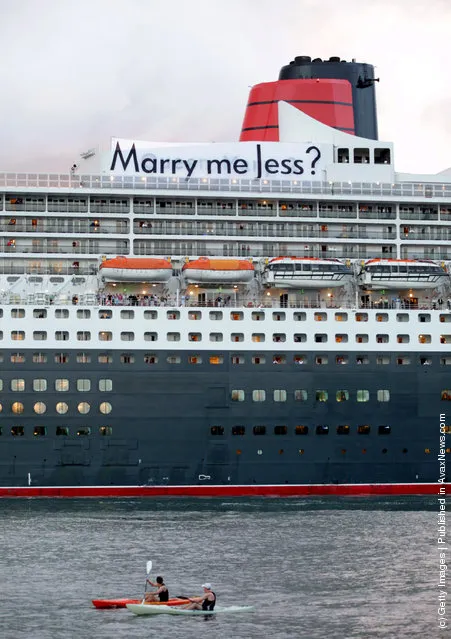 A banner with the message 'Marry Me Jess?' hangs from the funnel of the Queen Mary 2 as it arrives into Sydney Harbour on Valentines day, February 14, 2012 in Sydney, Australia