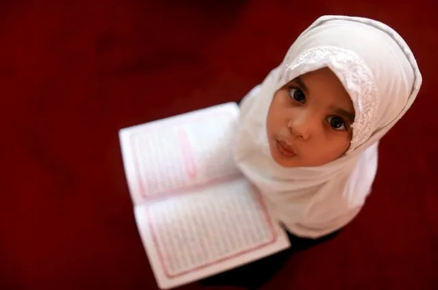 A girl reads the Koran at a Koranic school during the Muslim holy fasting month of Ramadan, in Benghazi, Libya July 5, 2015. (Photo by Esam Omran Al-Fetori/Reuters)