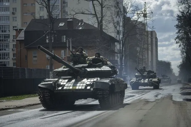 Ukrainian tanks move down a street in Irpin, on the outskirts of Kyiv, Ukraine, Monday, April 11, 2022. (Photo by Evgeniy Maloletka/AP Photo)