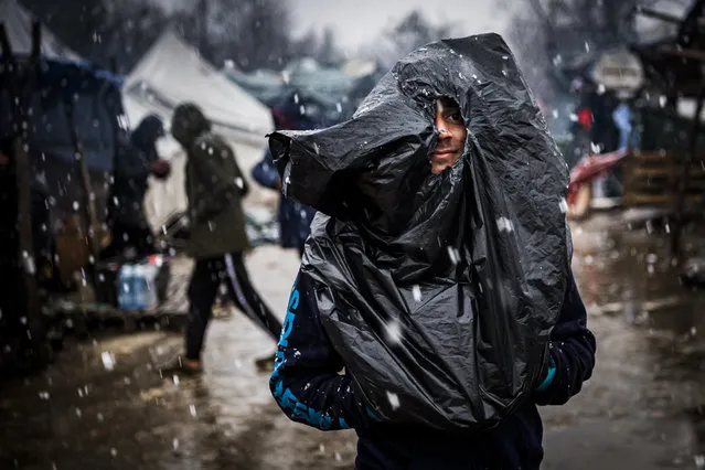 A migrant walks covered with a plastic bag at the Vucjak refugee camp outside Bihac, Bosnia and Herzegovina, 02 December 2019 (issued 03 December 2019. According to local media, hundreds of people remain at the camp even after International officials called for it to be shut down. (Photo by Jean-Christophe Bott/EPA/EFE)