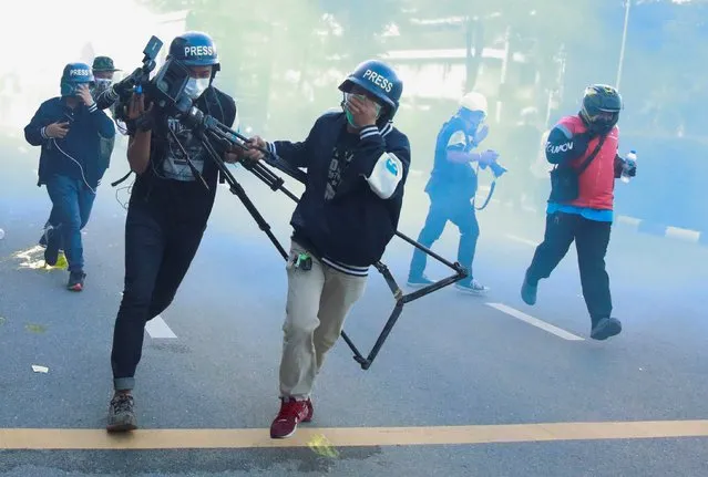 Members of the media run as they react to tear gas during a protest over the government's handling of the coronavirus disease (COVID-19) pandemic, in Bangkok, Thailand, August 16, 2021. (Photo by Soe Zeya Tun/Reuters)