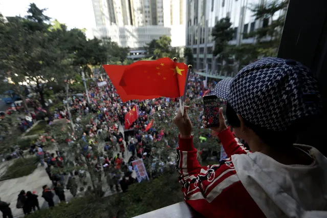 Pro-Beijing supporters wave the Chinese national flags during a rally in Hong Kong on Saturday, December 7, 2019. Six months of unrest have tipped Hong Kong's already weak economy into recession. (Photo by Mark Schiefelbein/AP Photo)