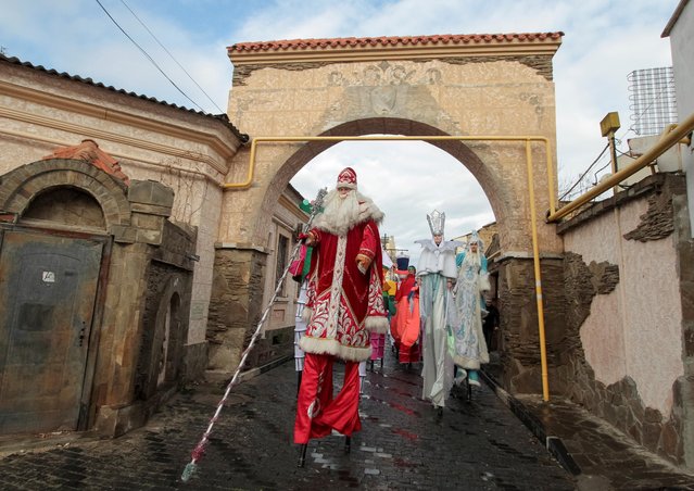 Revellers walk on a street during a parade to celebrate the upcoming Christmas and New Year in Yevpatoriya, Crimea on December 14, 2019. (Photo by Alexey Pavlishak/Reuters)