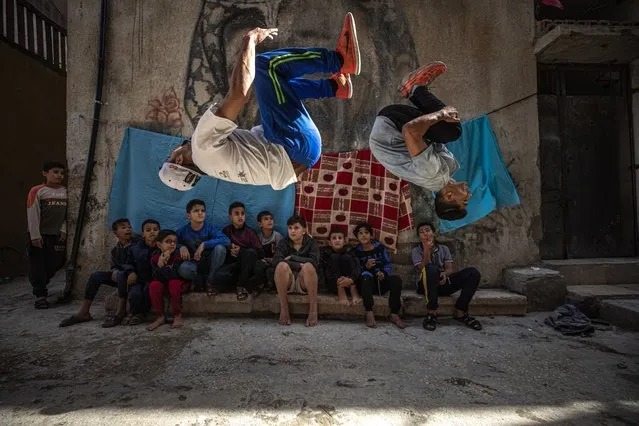 Palestinian youth practice parkour in Al-Shati refugee camp on November 12, 2021 in Gaza City, Gaza. For many young people living in Gaza, the years of living under a blockade effectively cutting them off from the outside world has taken a heavy toll with mental health levels rising among young people. The constant struggle of living with food and water insecurities and regular power outages, skyrocketing youth unemployment and rising suicide rates especially amongst men aged 18-30, many young people turn to sport and other recreational activities to relieve the pressures of everyday life, from boxing to horse riding many young people have found creative outlets to help release mental stress. (Photo by Fatima Shbair/Getty Images)