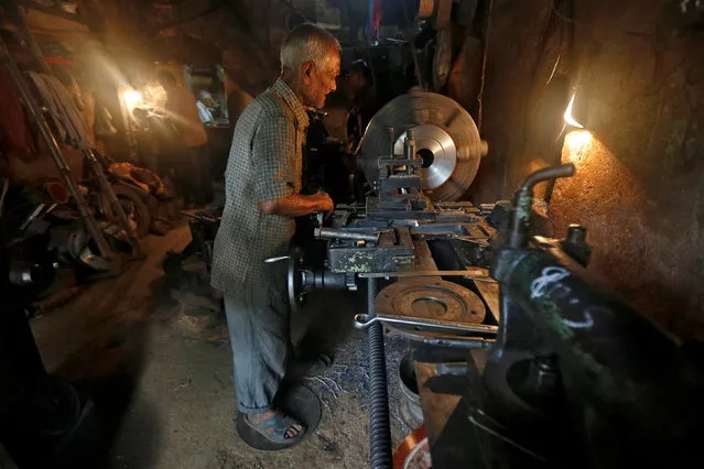 A worker operates a lathe as he makes spare parts of drilling machines at a workshop in Kolkata, India, June 10, 2016. (Photo by Rupak De Chowdhuri/Reuters)