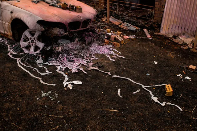 This handout photo taken on January 8, 2020 and received on January 9 from environment group Greenpeace Australia-Pacific shows a destroyed car which melted when bushfires hit properties in the area of Conjola Park on the south coast of New South Wales on January 4. Haunting images of koalas with singed fur, possums with burnt paws or countless charred kangaroo carcasses have flashed around the world and have come to symbolise a nation and an environment buckling under the weight of a climate-fuelled crisis. (Photo by Andrew Quilty/Greenpeace Australia Pacific/AFP Photo)