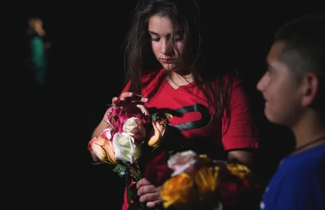 A young girl holds flowers outside the Willie de Leon Civic Center where people gather to mourn in Uvalde, Texas, May 24, 2022. A teenage gunman killed 19 young children in a shooting at an elementary school in Texas on Tuesday, in the deadliest US school shooting in years The attack in Uvalde, Texas – a small community about an hour from the Mexican border – is the latest in a spree of deadly shootings in America, where horror at the cycle of gun violence has failed to spur action to end it. (Photo by Allison Dinner/AFP Photo)