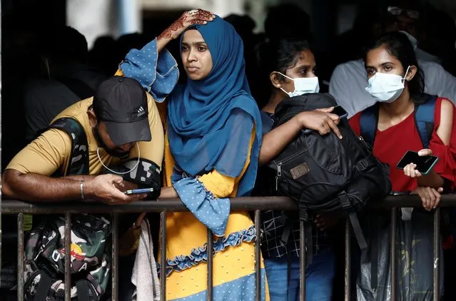 People gather at the main bus stand to catch a bus before curfew starts, after a clash between anti-government demonstrators and Sri Lanka's ruling party supporters, amid the country's economic crisis, in Colombo, Sri Lanka, May 12, 2022. (Photo by Dinuka Liyanawatte/Reuters)