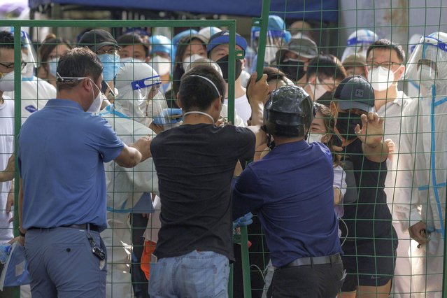 People try to break out of quarantine fence during the protest, amid new round of COVID-19 lockdowns, in Shanghai, China, 06 June 2022. Since 01 June, Shanghai lockdown was lifted as the city is still battling new sporadic community COVID-19 cases. Mandatory emergency PCR testing have been administrated in all medium and high-risk neighboring compounds. People in high and medium risk areas must have daily PCR testing for two weeks. If all residents remain negative for COVID-19, they will be marked as low risk area. (Photo by Alex Plavevski/EPA/EFE)