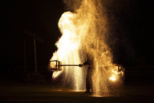 A performer walks carrying fire during a fire spectacle to celebrate Mid Autumn Festival in Beijing, China, 15 September 2024. The Mid-Autumn Festival, also known as the Mooncake Festival, is celebrated on the 15th of the eighth lunar month. (Photo by Andres Martinez Casares/EPA/EFE)