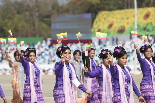 A traditional artist group waves miniature national flags during a ceremony to mark Myanmar's 75th anniversary Union Day in Naypyitaw, Myanmar, Saturday, February 12, 2022. (Photo by AP Photo/Stringer)