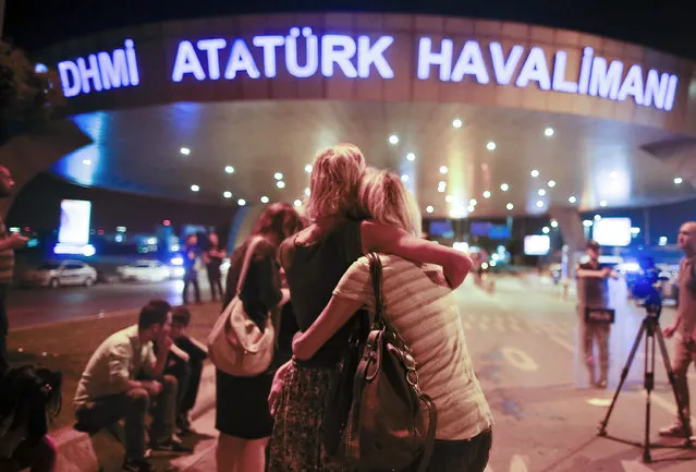 Passengers embrace each other at the entrance to Istanbul's Ataturk airport, early Wednesday, June 29, 2016 following their evacuation after a blast. Suspected Islamic State group extremists have hit the international terminal of Istanbul's Ataturk airport, killing dozens of people and wounding many others, Turkish officials said Tuesday. (Photo by Emrah Gurel/AP Photo)