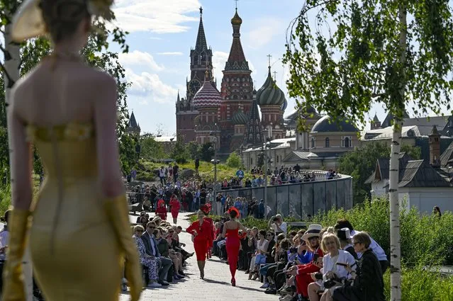 A model displays the collection by Russian designer Slava Zaitsev during the opening of the Fashion Week in at Zaryadye Park with the Spasskaya Tower and St. Basil's Cathedral in the background near Red Square in Moscow, Russia, Monday, June 20, 2022. Neither inflation nor the war in Ukraine are threatening to take a bite out of the luxury fashion market, according to a study published Tuesday, June 21, 2022. (Photo by AP Photo/Stringer)