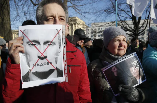 A protester holds a poster reading “Tired of” during a rally in memory of opposition leader Boris Nemtsov in St. Petersburg, Russia, Saturday, February 29, 2020. Nemtsov, a charismatic Russian opposition leader and sharp critic of President Vladimir Putin, was gunned down on Feb. 27, 2015 near the Kremlin in Moscow, Russia. (Photo by Dmitri Lovetsky/AP Photo)