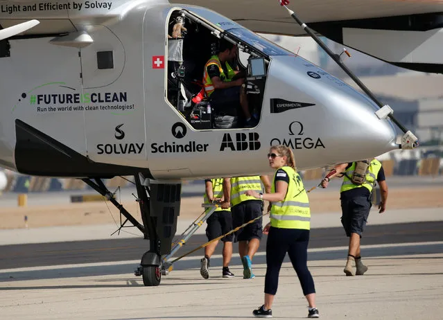 The ground crew of Solar Impulse 2, a solar powered plane, surround the aircraft after it landed at Cairo Airport, Egypt July 13, 2016. The Solar Impulse 2 landed in Cairo on Wednesday for its penultimate stop as the solar-powered plane nears the end of its marathon tour around the world. After setting off from Seville on Monday morning, the plane passed through Algerian, Tunisian, Italian and Greek airspace, and flew over the Giza Pyramids before touching down at Cairo airport at around 7:10am (5:10am GMT). (Photo by Amr Abdallah Dalsh/Reuters)