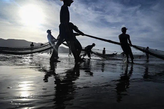 Fishermen pull their net to fish along the coast at a beach in Pekan Bada, Indonesia's Aceh province on July 17, 2022. (Photo by Chaideer Mahyuddin/AFP Photo)