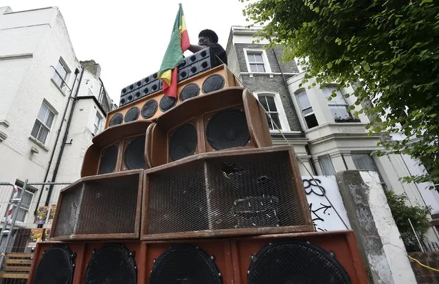 A man assembles his speaker stacked on a street at the Notting Hill Carnival in west London August 30, 2015. (Photo by Toby Melville/Reuters)
