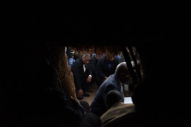 Botswana President Duma Boko kneels as a show of respect during the funeral and memorial service of the late Pitseng Gaoberekwe in Metsiamanong village, Central Kalahari Game Reserve (CKGR), on December 9, 2024. Pitseng Gaoberekwe, a prominent San elder and historical figure, died in 2021, sparking a legal battle over his burial in his ancestral land, the Central Kalahari Game Reserve (CKGR). After nearly three years of disputes, the Botswana government finally agreed to his burial wish in December 2024. (Photo by Monirul Bhuiyan/AFP Photo)