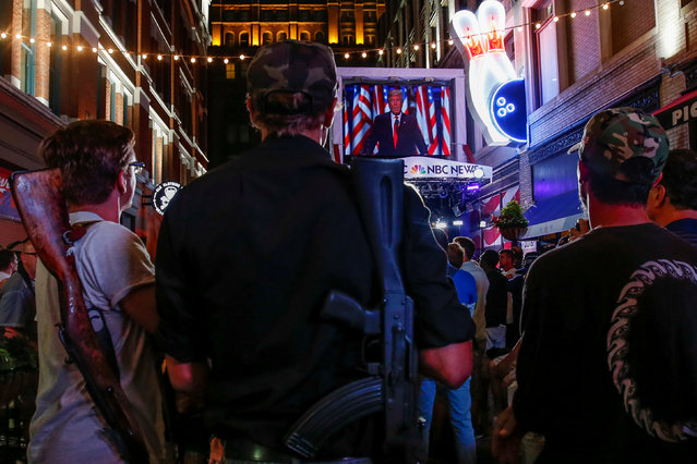 Kevin Kvasnicka (L) and Jesse Gonzales openly carry firearms as they watch U.S. Republican presidential nominee Donald Trump speak on a big screen television along East 4th street during the Republican National Convention in Cleveland, Ohio, U.S., July 21, 2016. (Photo by Adrees Latif/Reuters)