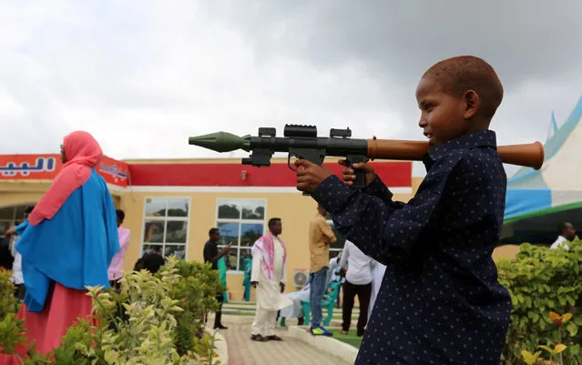 A Somali boy plays with a toy model of a rocket-propelled grenade (RPG) after attending Eid al-Fitr prayers to mark the end of the fasting month of Ramadan in Somalia's capital Mogadishu, July 6, 2016. (Photo by Feisal Omar/Reuters)