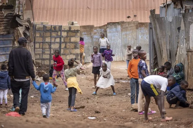 Children play ball games on a dirt street in the Kibera neighborhood of Nairobi, Kenya Sunday, August 14, 2022. (Photo by Ben Curtis/AP Photo)