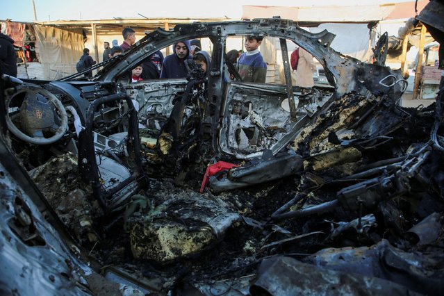 Palestinian children inspect the remains of a car in the aftermath of an Israeli strike, amid the Israel-Hamas conflict, in Khan Younis in the southern Gaza Strip on December 23, 2024. (Photo by Hatem Khaled/Reuters)