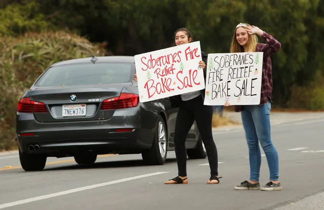 High school freshmen Zully Martinez (L) and Scout Curry hold a “Soberanes Fire Relief Bake Sale” in Carmel, California, U.S. July 29, 2016. (Photo by Michael Fiala/Reuters)
