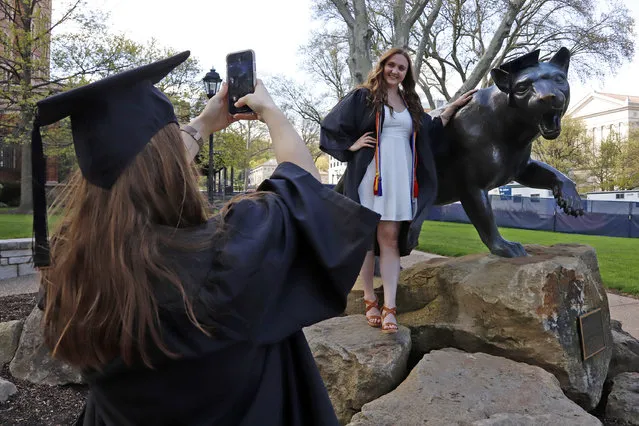 Class of 2020 University of Pittsburgh graduates Shannon Trombley, left, of Philadelphia, and Julie Jones, of West Chester, Pa., take turns posing for photos with a statue of Pitt's mascot, the Pitt Panther, Monday, April 27, 2020. Pitt held a virtual Commencement Ceremony for the Class of 2020 on Sunday, April 26, 2020 due to social distancing implemented due to COVID-19. (Photo by Gene J. Puskar/AP Photo)