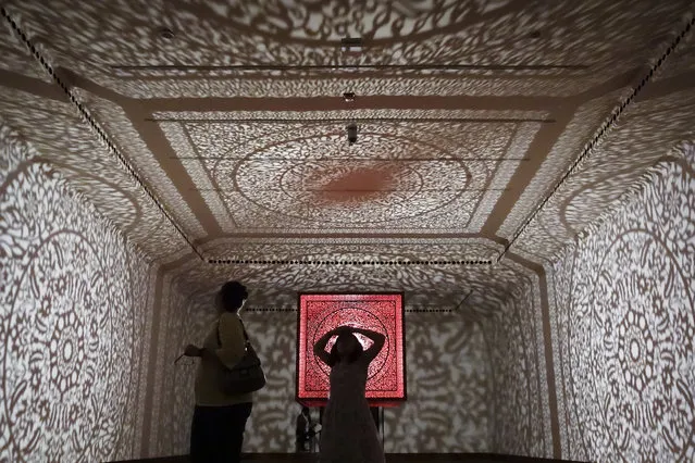 Visitors browse an installation of Pakistani-American artist Anila Agha's “All the Flowers are for Me” at the Cincinnati Art Museum, Sunday, October 15, 2017, in Cincinnati. The piece draws its shadow casts from Islamic architectural styles and is meant to reflect artist's separation from her roots in Pakistan as she lives in the United States. (Photo by John Minchillo/AP Photo)