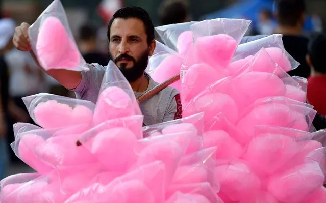 A vendor sells cotton candy during ongoing anti-government protests in downtown Beirut, Lebanon, 11 November 2019. Protests in Lebanon are continuing since first erupted on 17 October, as protesters aim to apply pressure on the country's political leaders over what they view as a lack of progress following the resignation of Prime Minister Saad Hariri on 29 October. (Photo by Wael Hamzeh/EPA/EFE)