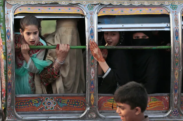 Women riding in a van react to something happening outside the van in Rawalpindi, Pakistan October 5, 2017. (Photo by Caren Firouz/Reuters)