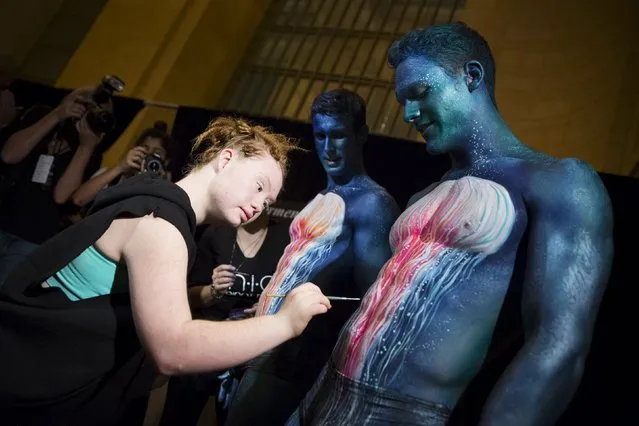 Madeline Stuart, an Australian model with Down Syndrome, assists with body painting models backstage before the FTL Moda Presentation of the Spring/Summer 2016 collection during New York Fashion Week in Vanderbilt Hall at Grand Central Station, New York, September 13, 2015. (Photo by Andrew Kelly/Reuters)