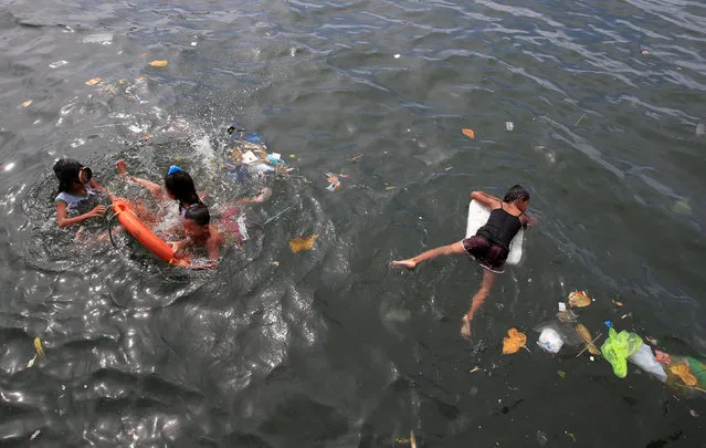 Children swim in polluted waters of Manila bay, metro Manila, Philippines August 15, 2016. (Photo by Romeo Ranoco/Reuters)