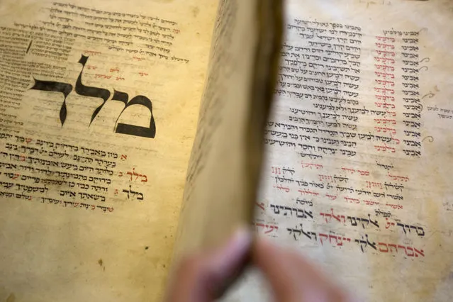 In this photo taken Sunday, October 5, 2014, a library official shows a 13th-century German prayer book containing the earliest evidence of the Yiddish language, at Israel's National Library in Jerusalem. (Photo by Sebastian Scheiner/AP Photo)