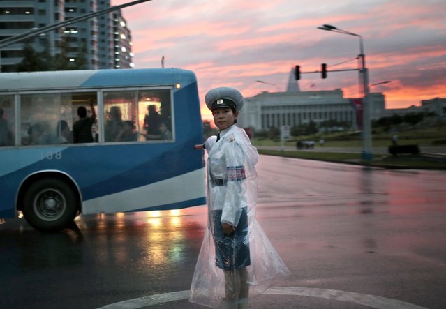 A traffic police officer directs vehicles at a street junction during sunset in Pyongyang, North Korea, Thursday, August 25, 2016. (Photo by Dita Alangkara/AP Photo)
