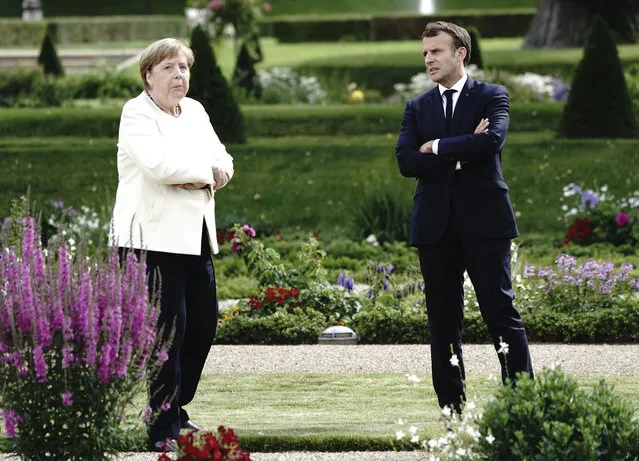 French President Emmanuel Macron talks to German Chancellor Angela Merkel during a meeting at Meseberg Castle, the German government's guest house in Meseberg, Germany, June 29, 2020. One of the topics of the meeting is the European reconstruction plan of 750 billion euros in the Corona crisis. (Photo by Kay Nietfeld/dpa via AP Photo)