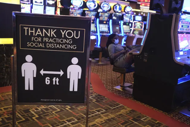 A sign asks people to practice social distancing the Golden Nugget Casino in Atlantic City, N.J., Thursday, July 2, 2020. Eager to hit the slot machines and table games after a 108-day absence, gamblers wore face masks and did without smoking and drinking Thursday as Atlantic City's casinos reopened amid the coronavirus pandemic that has drastically changed things both inside and outside the casino walls. (Photo by Seth Wenig/AP Photo)