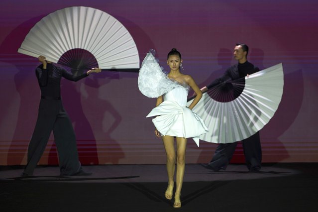 A model wears the latest fashion from Huqiu Bridal City during China Fashion Week in Beijing, Friday, March 21, 2025. (Photo by Ng Han Guan/AP Photo)