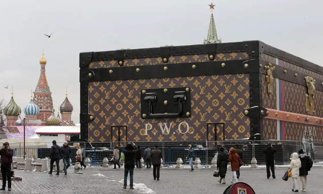 People walk past a Louis Vuitton pavilion in the shape of a giant suitcase, as the St. Basil's Cathedral (L) and the Spasskaya Tower are seen in the background, in central Moscow, November 27, 2013. (Photo by Tatyana Makeyeva/Reuters)