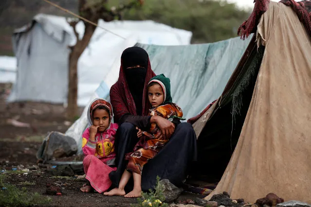 A woman and her daughters sit outside their tent at a camp for internally displaced people near Sanaa, Yemen, August 15, 2016. (Photo by Khaled Abdullah/Reuters)