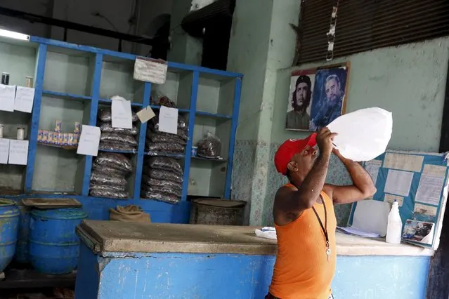 A man looks into a plastic bag while standing inside a subsidised state store, or “bodega”, where Cubans can buy basic products with a ration book they receive annually from the government  in Havana September 18, 2015. (Photo by Carlos Garcia Rawlins/Reuters)