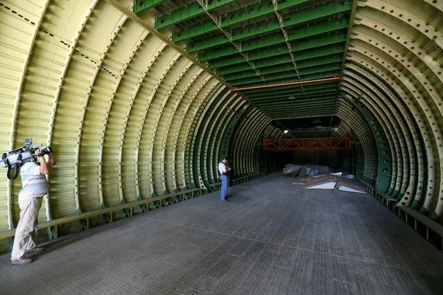 Journalists stand inside an airframe for the second Antonov-225 Mriya plane at Antonov aircraft plant in Kiev, Ukraine, September 7, 2016. Picture taken with a fish-eye lens. (Photo by Valentyn Ogirenko/Reuters)