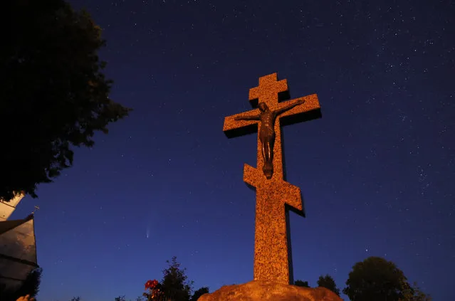 C/2020 F3, or Comet NEOWISE (L), flies across the night sky behind an Orthodox cross in Zaslavl, Belarus, 21 July 2020. The comet's path passed nearest to the Sun on 03 July, while its closest approach to Earth is set to occur on 23 July. (Photo by Tatyana Zenkovich/EPA/EFE)
