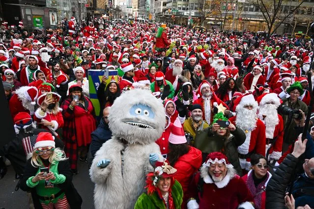 People dressed in Santa Claus costumes participate in SantaCon on December 10, 2022 in New York City. SantaCon is an annual Christmas-themed pub crawl that raises money for charity. This year, SantaCon created a map and partnered with the app, Wolfie, to display real-time updates about lines, venues, and friends’ locations. (Photo by Alexi Rosenfeld/Getty Images)