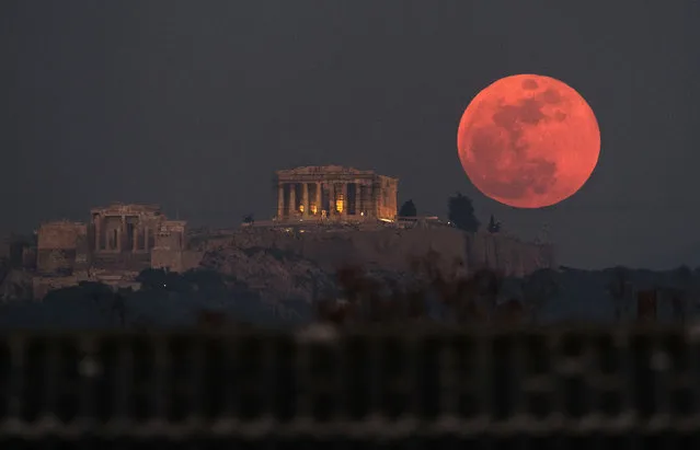 A super blue blood moon rises behind the 2,500-year-old Parthenon temple on the Acropolis of Athens, Greece, on Wednesday, January 31, 2018. (Photo by Petros Giannakouris/AP Photo)