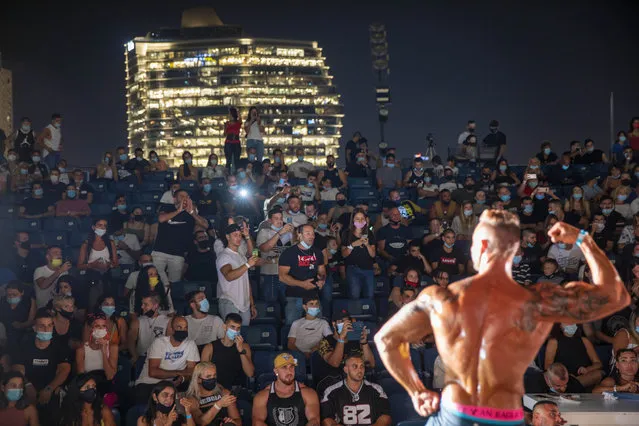 A contestant participates in the final round during the National Amateur Body Builders Association competition in Tel Aviv, Israel, Wednesday, August 19, 2020. Because of the coronavirus pandemic, this year's competition was staged outdoors in Tel Aviv. The 85 participants were required to don protective masks in line with health codes. (Photo by Oded Balilty/AP Photo)