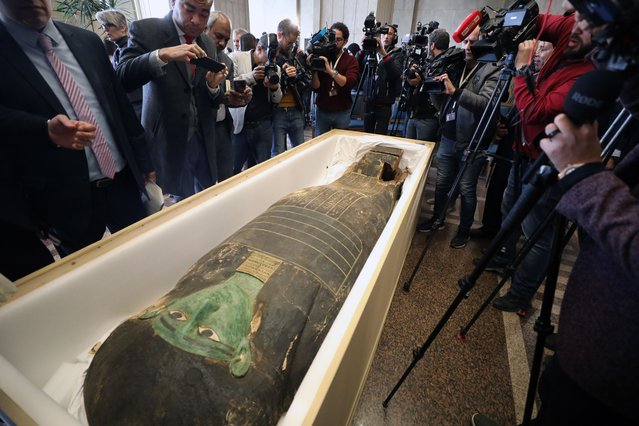 Reporters take photographs of the ancient Egyptian artefact “Green Sarcophagus” displayed after it was returned from the Houston Museum of Natural Sciences, in Cairo, Egypt, 02 January 2023. Egyptian Foreign Minister Sameh Shoukry and US Charge of Affairs Daniel Rubinstein attended a ceremony on 02 January to celebrate the handing over of the coffin lid known as the “Green Sarcophagus” that was smuggled illegally outside of Egypt and recovered from the Houston Museum of Natural Sciences. The artefact is three meters long carved in wood with columns of hieroglyphic texts dating back to the Late Period (664-332 BC). (Photo by Khaled Elfiqi/EPA/EFE)